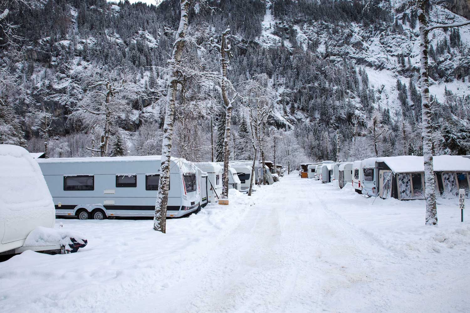 Winter camping with caravan. Camp site in the snow. Camping and